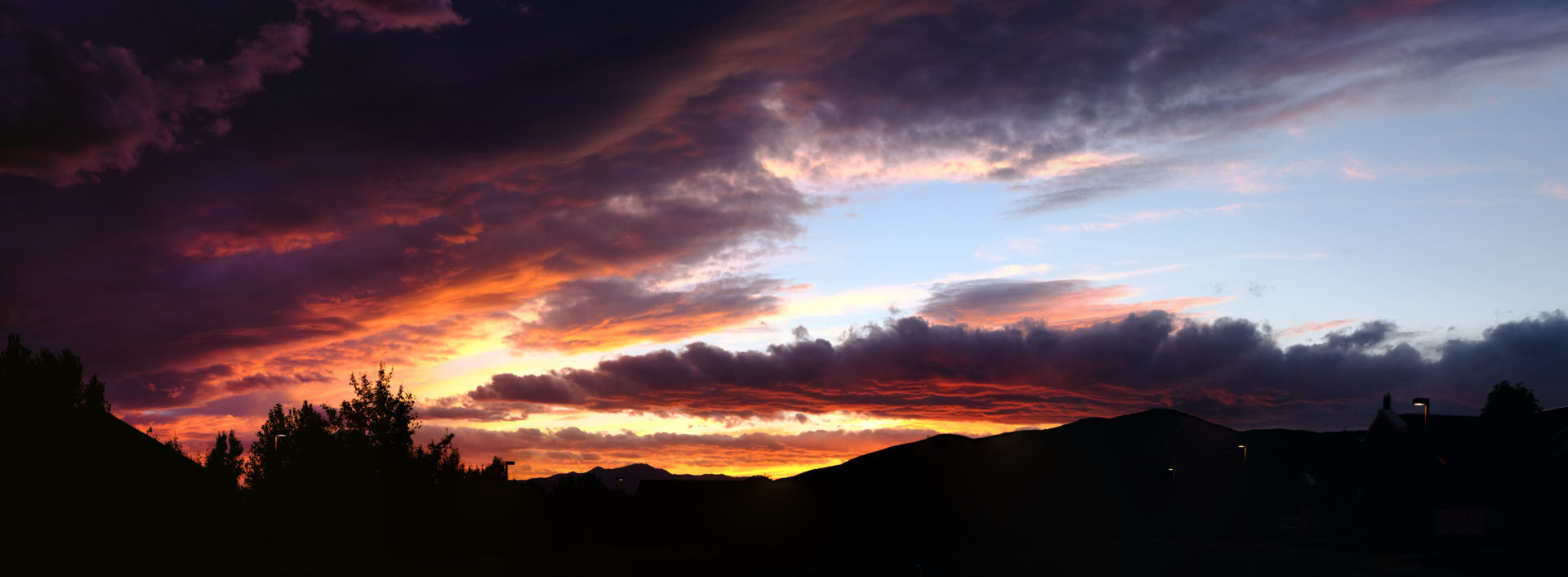 A beautiful sunset panorama filled with purples and oranges and reds from the layers of clouds.