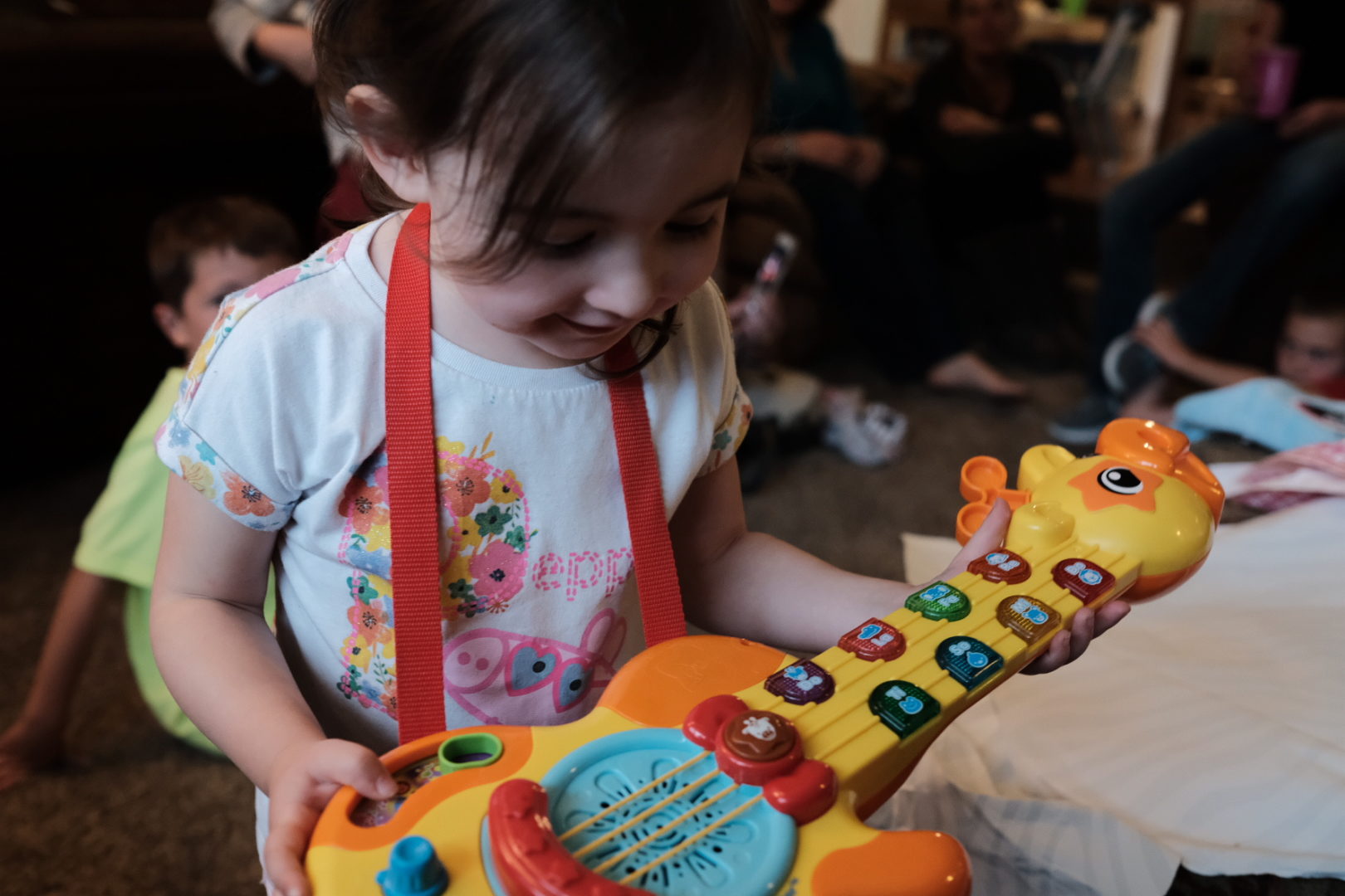 A little girl holds her toy guitar on her birthday