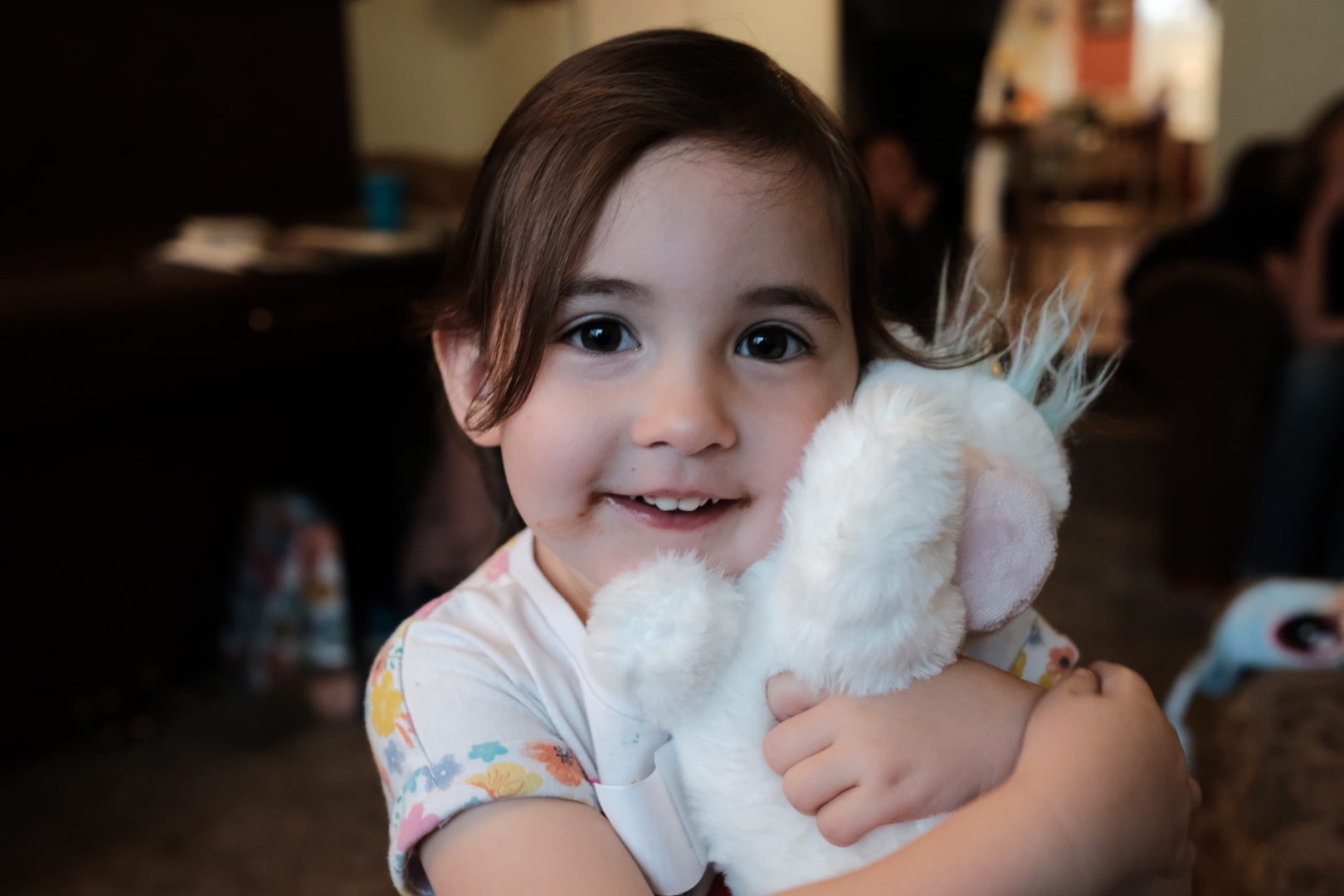 A little girl holds her unicorn stuffed animal