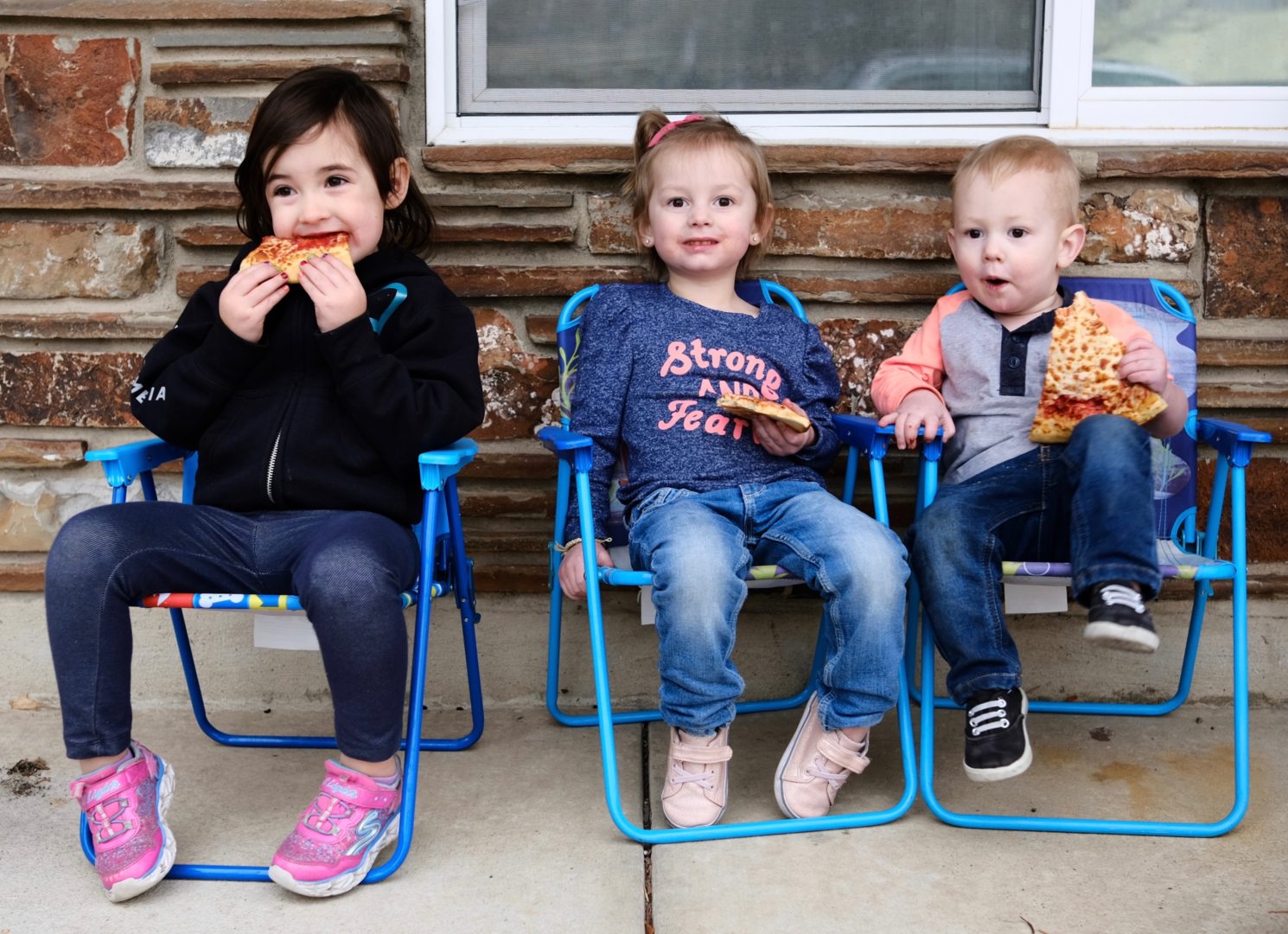3 Kids sitting in folding chairs on the porch